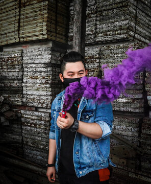 Man in blue denim button up vest holding purple powder