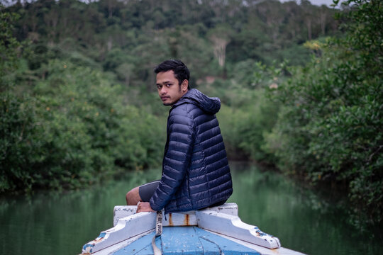 Man in bubble jacket sitting on boat