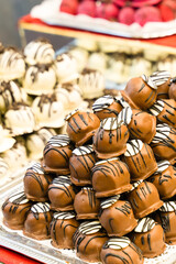 sweets covered with chocolate glaze with white pattern stacked stack on blurred background