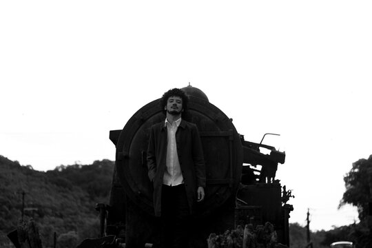 Man standing beside train in grayscale