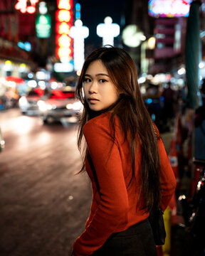 Portrait of Woman standing in a city during night time