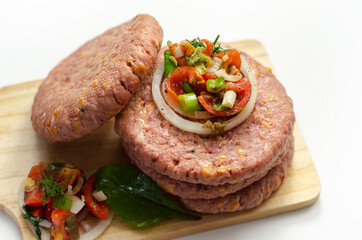 Raw beef burgers blended with caramelised red onion and tangy red Leicester cheese prepared for grilling