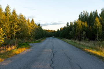 Fototapeta na wymiar Empty autumn road in Finland during sunset