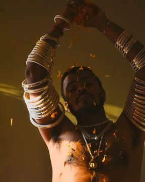 Topless man wearing Indian jewelries and dancing