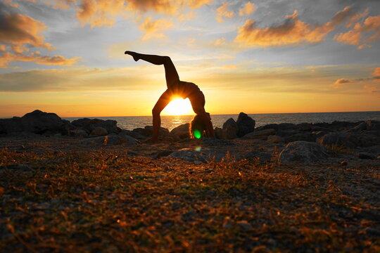 woman back bending on seashore during sunset