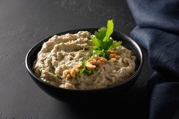 Baba ganoush Asian cuisine appetizer made from baked eggplant with parsley, garlic on black...