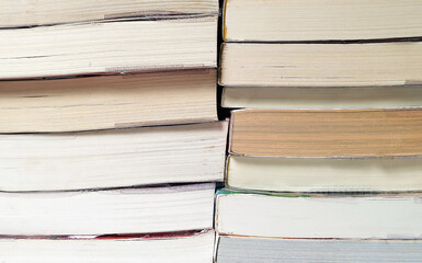 close-up view stacked of old books random pattern. stacks of old paperback books in the. the color of the paper is different , the superimposed is disordered.