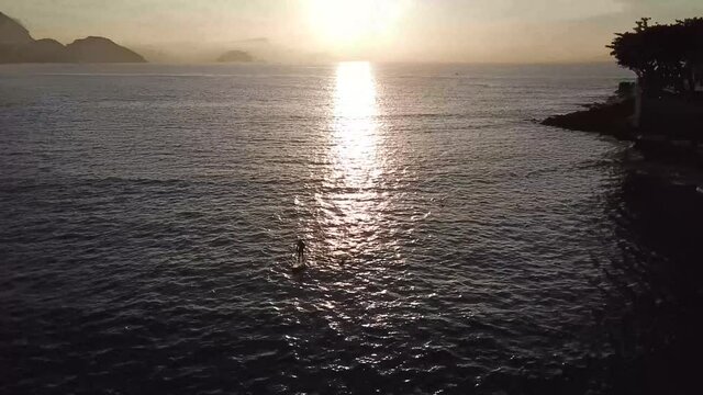 Two Swimmers And A Man On Stand Up Padle