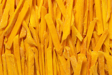 Dry tasty mango slices as a background.