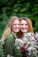 Naklejka premium portrait of two smiling young woman hugging outdoors
