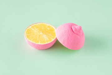 Two halves of a pink lemon arranged on a light green background. Minimal fruit summer concept