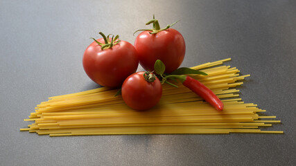 the cooking ingredients tomatoes spaghetti an pepper