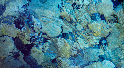Pebbles under water , abstract sea water background, blue colors