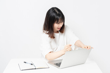 ノートパソコンを使いながら起こっている若い女性
