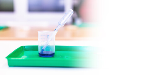 Microscopy and used laboratory glasses for the microscope are on a green tray after the study. results of clinical trials. laboratory studies of drugs, blood and vaccines