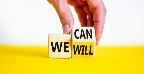We can and will symbol. Businessman turns a cube and changes words we can to we will. Beautiful...