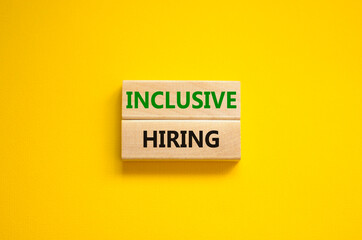 Inclusive hiring symbol. Wooden blocks with words Inclusive hiring on beautiful yellow background....
