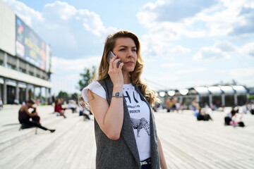 Fototapeta premium Serious female making international call conversation via mobile application using roaming internet connection, attractive Caucasian woman have consultancy conversation via smartphone technology