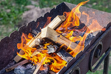 wood firewood lighting a flame in the grill close up