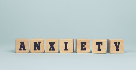 The word ANXIETY made from wooden cubes on blue background