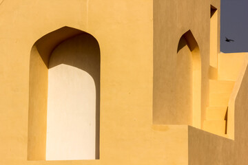 The exterior facade with arched windows of the ancient astronomical observatory of Jantar Mantar in the city of Jaipur in Rajasthan, India.