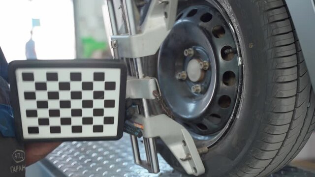 The mechanic installs the panel on the wheel to adjust the camber