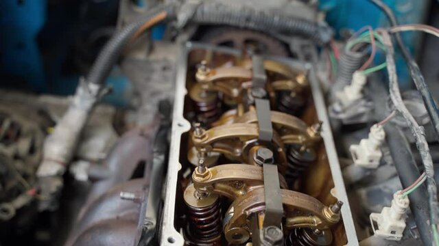 A mechanic repairs an old engine