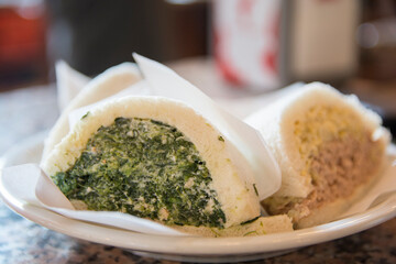 Sliced Tramezzini, triangular Italian sandwiches constructed from two slices of soft white bread, with the crusts removed, containing hard boiled egg and tuna fish, and spinach