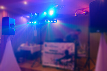 DJ plays music at wedding party. Colorful light rays