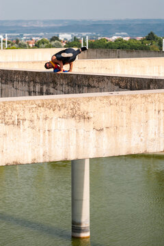 Break dancer performs a hand stand in rooftop