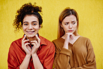 Smiling woman and pensive female friend