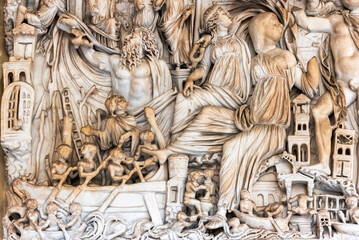 Close-up on decorative sculptures engraved on a marble wall representing an ancient roman battle scene in a coastal town © Giorgio G