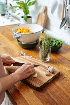 Woman chopping cloves of ripe garlic