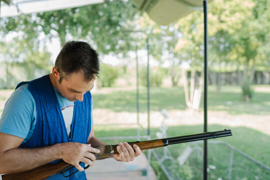 Mid Adult Man Training His Aim and Concentration Using a Shotgun in a Clay Pigeon Shooting Field Sport Centre 