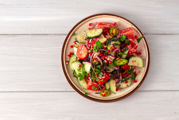 Traditional Georgian salad, Fresh vegetables, with walnut dressing, spices, herbs, pomegranate seeds, horizontal, no people,