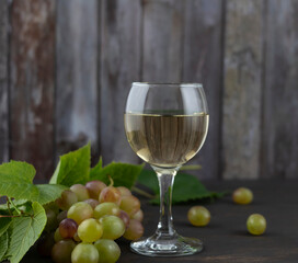 White wine in a clear glass glass on a dark wooden table