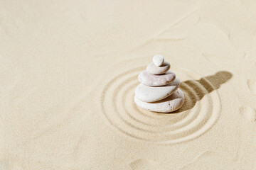Zen garden meditation sandy background with stone cairn and lines on sand. Relaxation balance and harmony