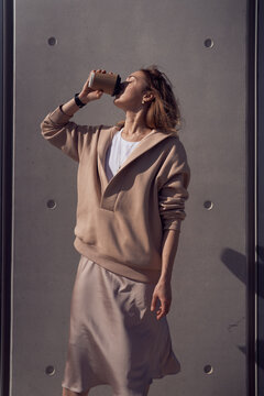 Woman drinking hot beverage on street