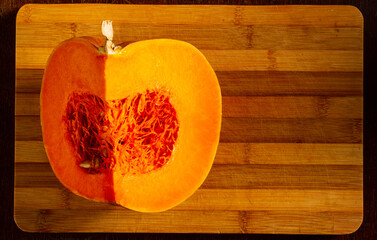 Cutted fresh orange big pumpkin on bamboo board, close up. Organic agricultural product,...