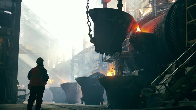 Steel mill worker is observing copper casting