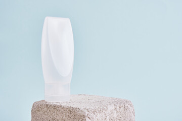Blank white plastic tube with flip top cap on square concrete podium Cosmetic beauty product...