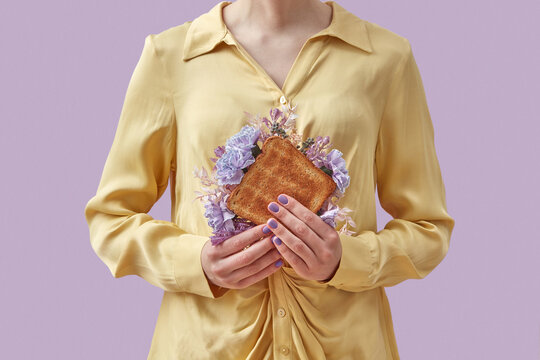 Woman holding sandwich with spring flowers
