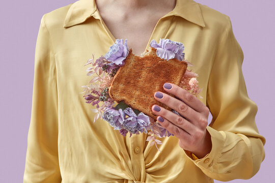 Woman holding bitten sandwich with flowers