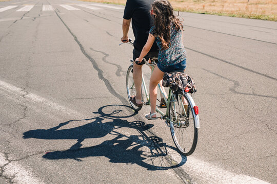 Father daughter tandem drop shadow on the asphalt
