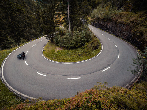 Sidecar motorcyclist driving on a narrow hairpin bend.