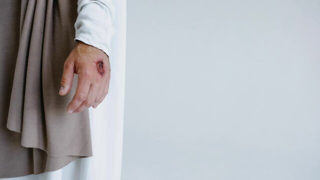 Jesus' hands with stigmata on a white background. Studio. High quality 4k footage