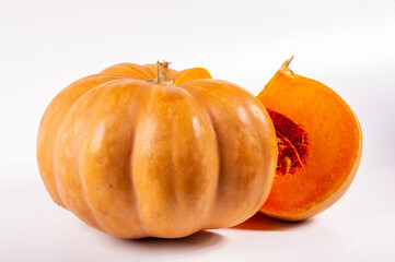 Whole fresh orange big pumpkin and slice of pumpkin on white background, closeup. Organic agricultural product, ingredients for cooking, healthy food vegan.