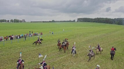Aerial wide view of reconstruction of the battle of 1812. Soldiers fire cannons and rifles, cavalry gallops. Explosions and shots on the battlefield. Historical concept.