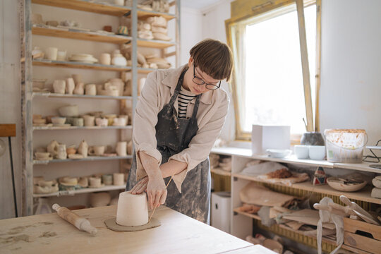 Female potter drawing circle on clay