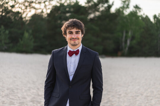 Young man wearing wedding suit posing in nature